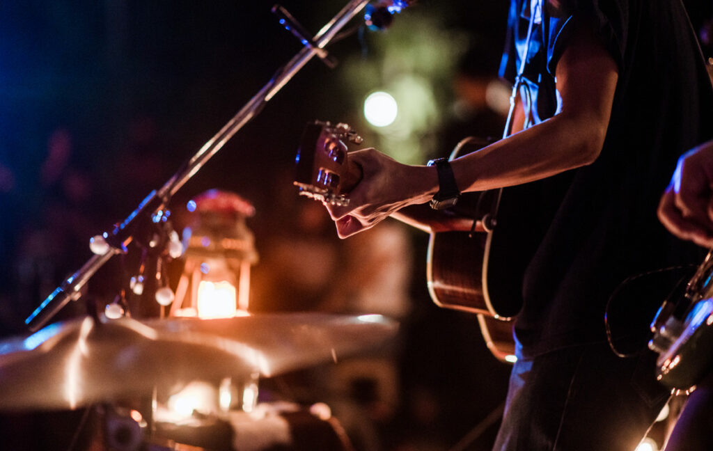 a guitarit on a stage with nice ambient lighting